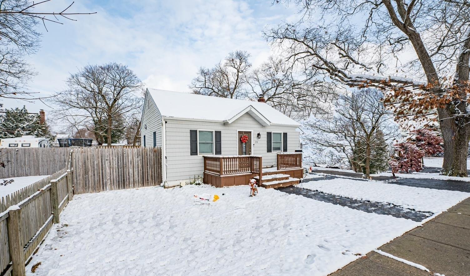 a view of a white house with a yard covered in snow