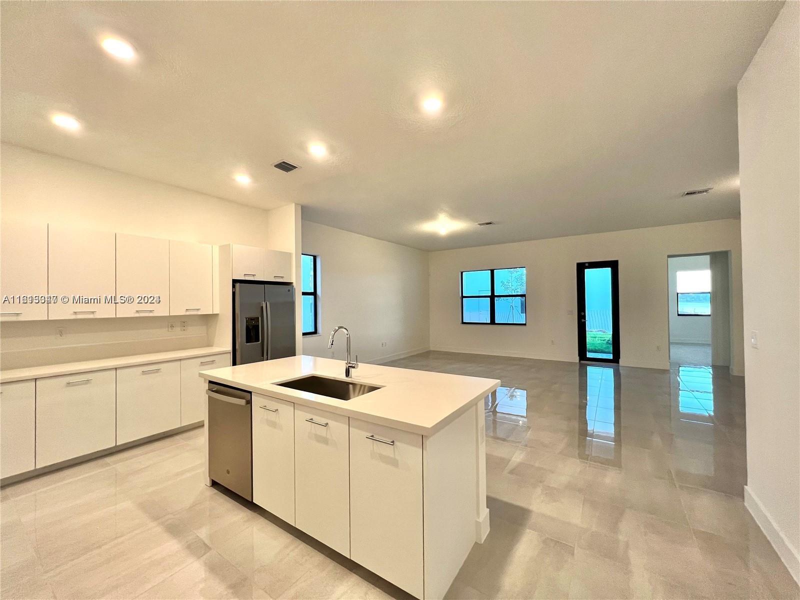 a kitchen that has a lot of cabinets in it and wooden floors