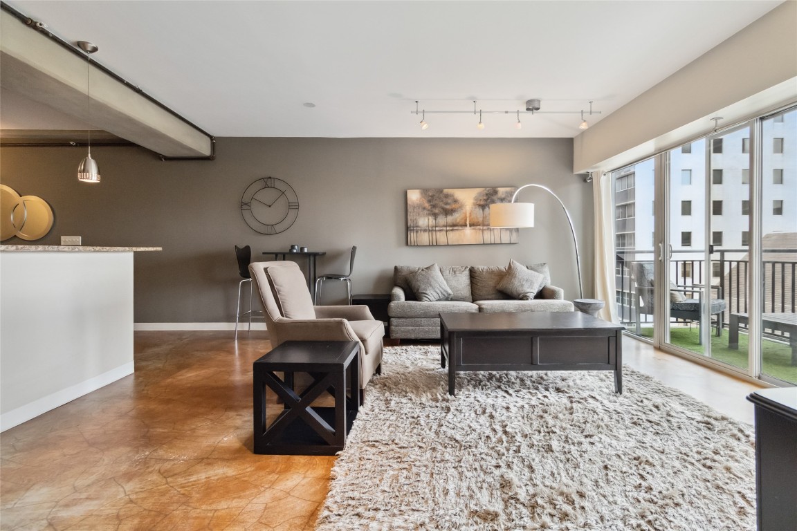 a living room with furniture wooden floor and a large window