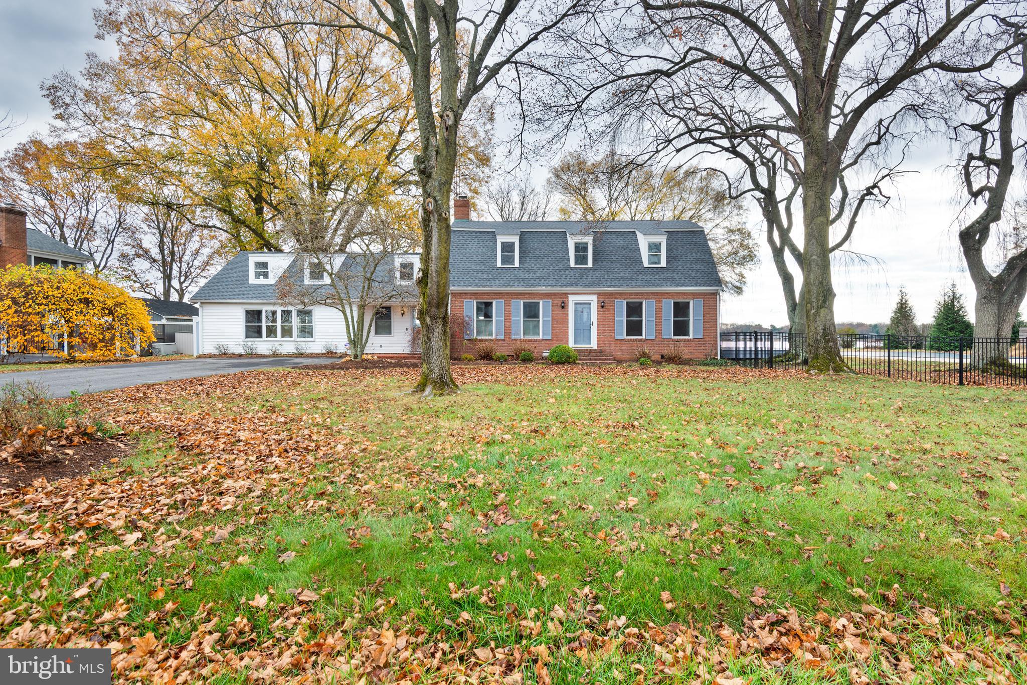 a brick house with trees in front of it