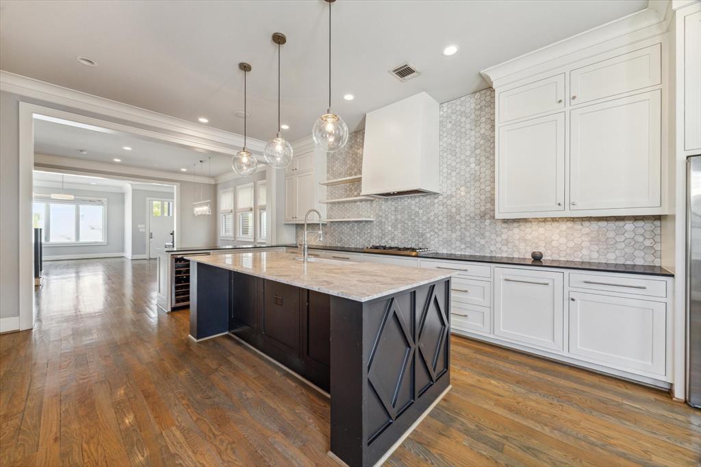 a kitchen with stainless steel appliances granite countertop a sink a stove and a wooden floors