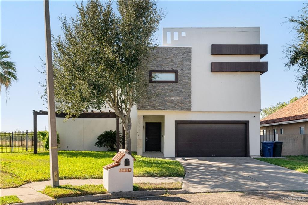 Contemporary house featuring a front yard and a garage