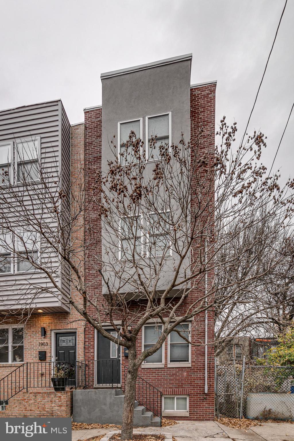 a front view of a building with large trees