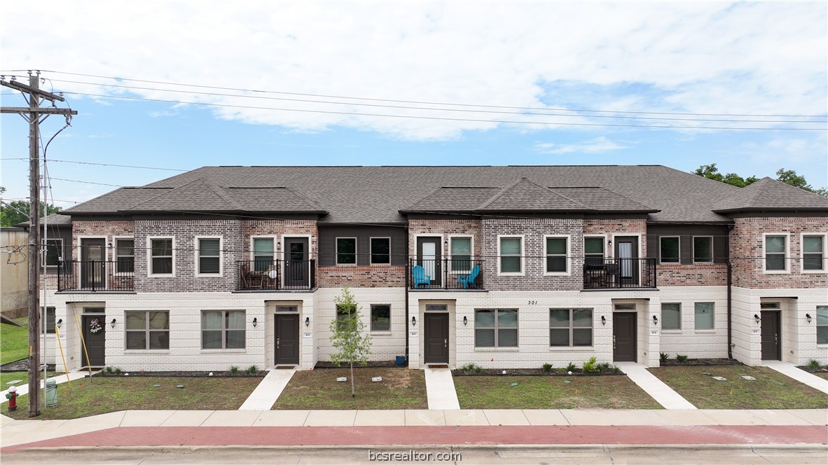 a front view of a residential apartment building with a yard