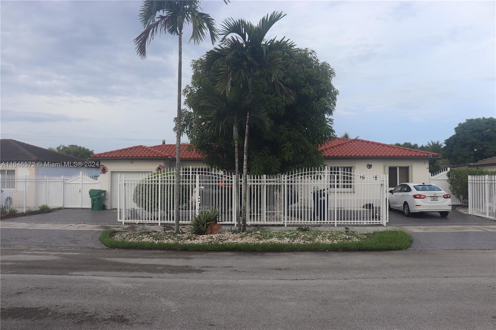 a front view of a house with a garden and parking