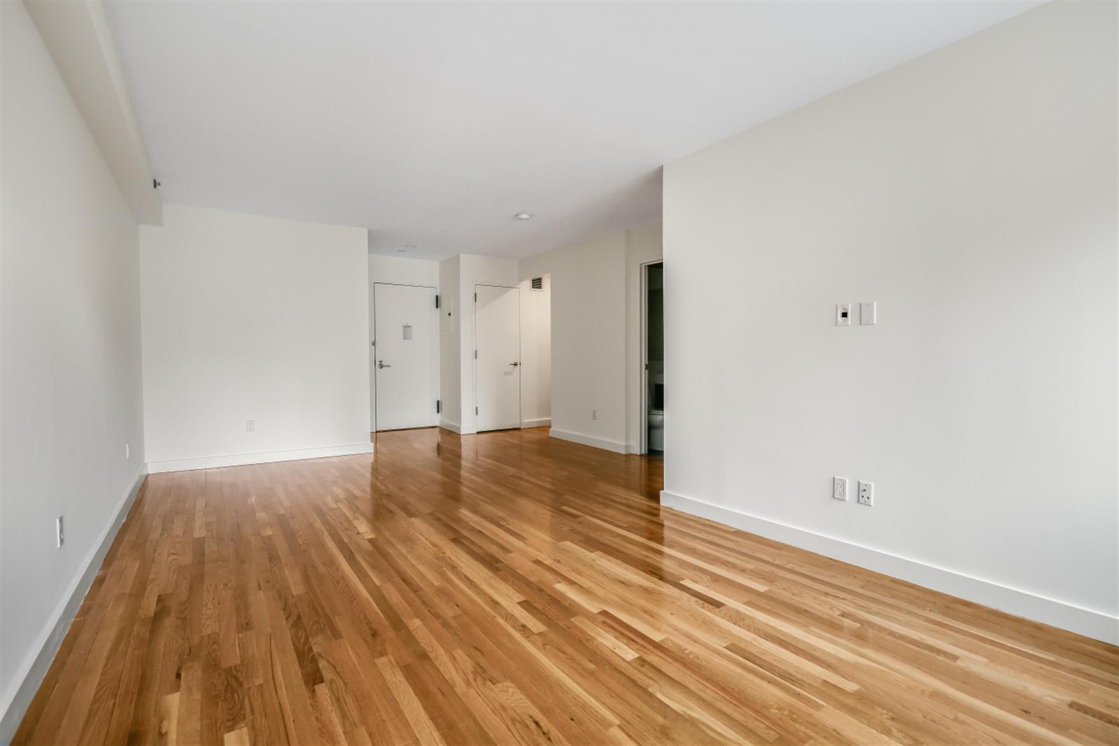 a view of empty room with wooden floor