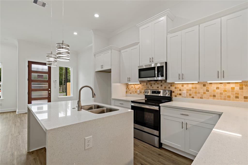 a kitchen with granite countertop a sink stainless steel appliances and cabinets