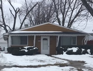 a view of a house with a yard covered in snow