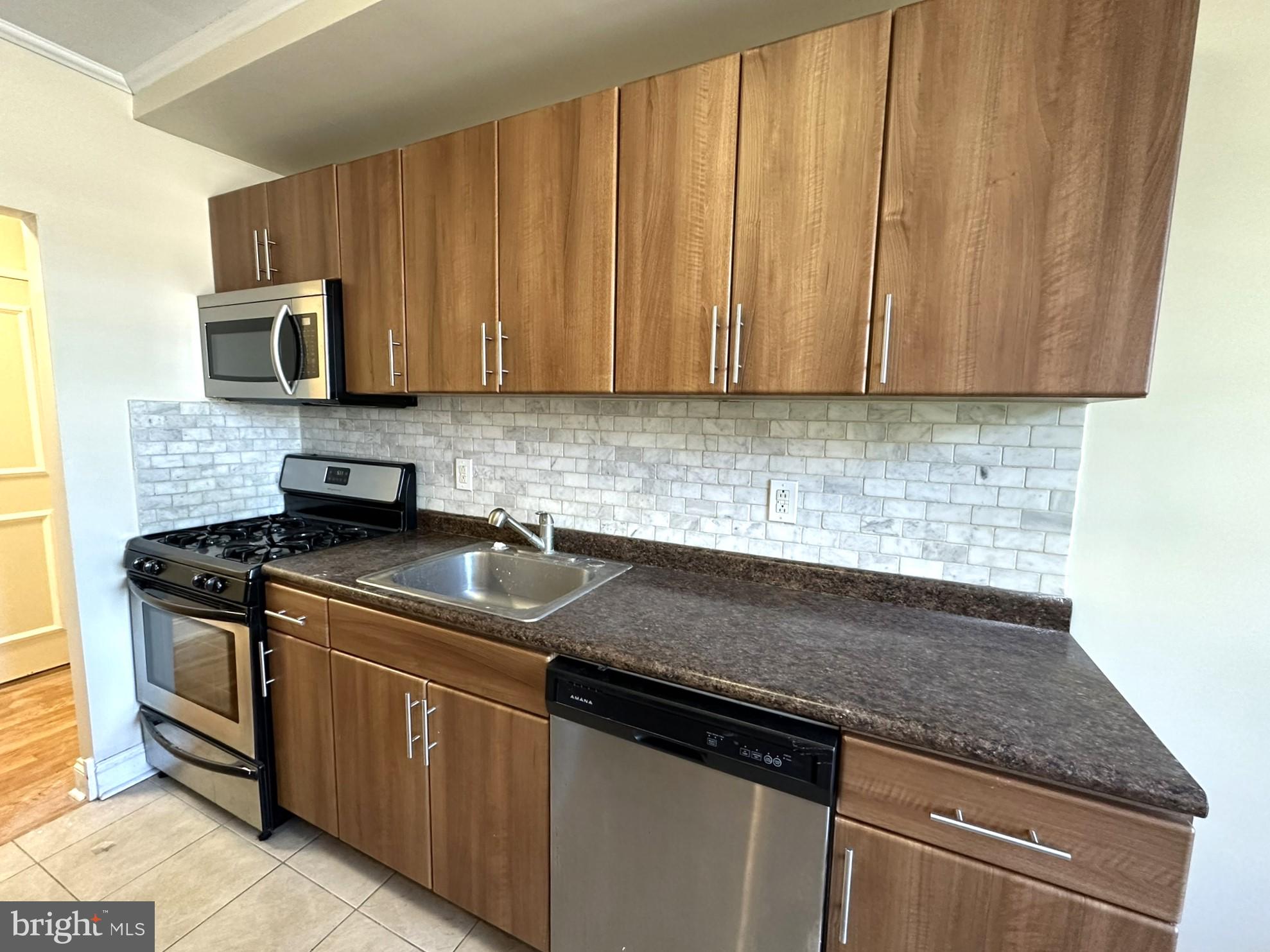 a kitchen with stainless steel appliances granite countertop a sink stove and microwave