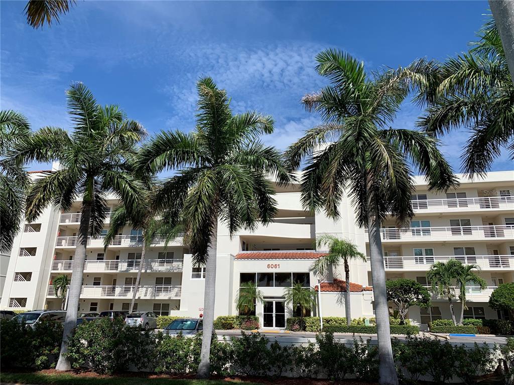 front view of a building with palm trees