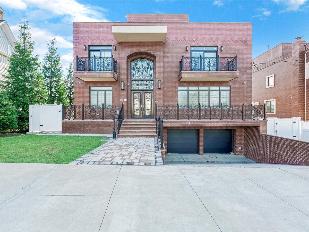 View of front facade featuring a front yard and a garage