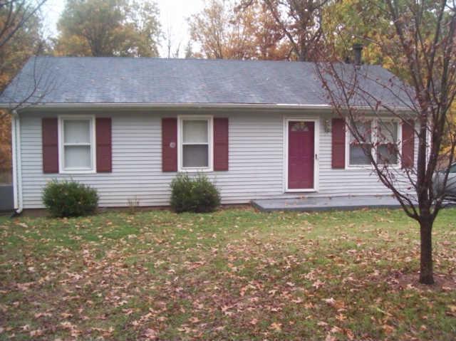 a view of a house with a yard and large tree