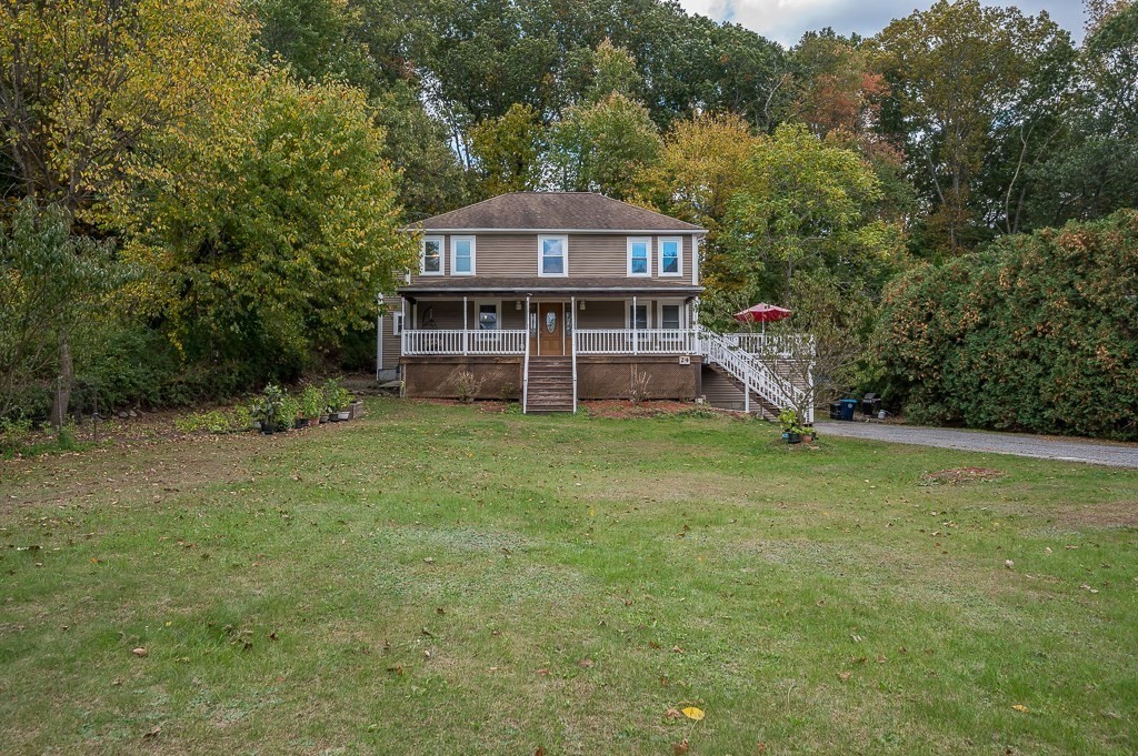 a view of a house with a big yard and large trees