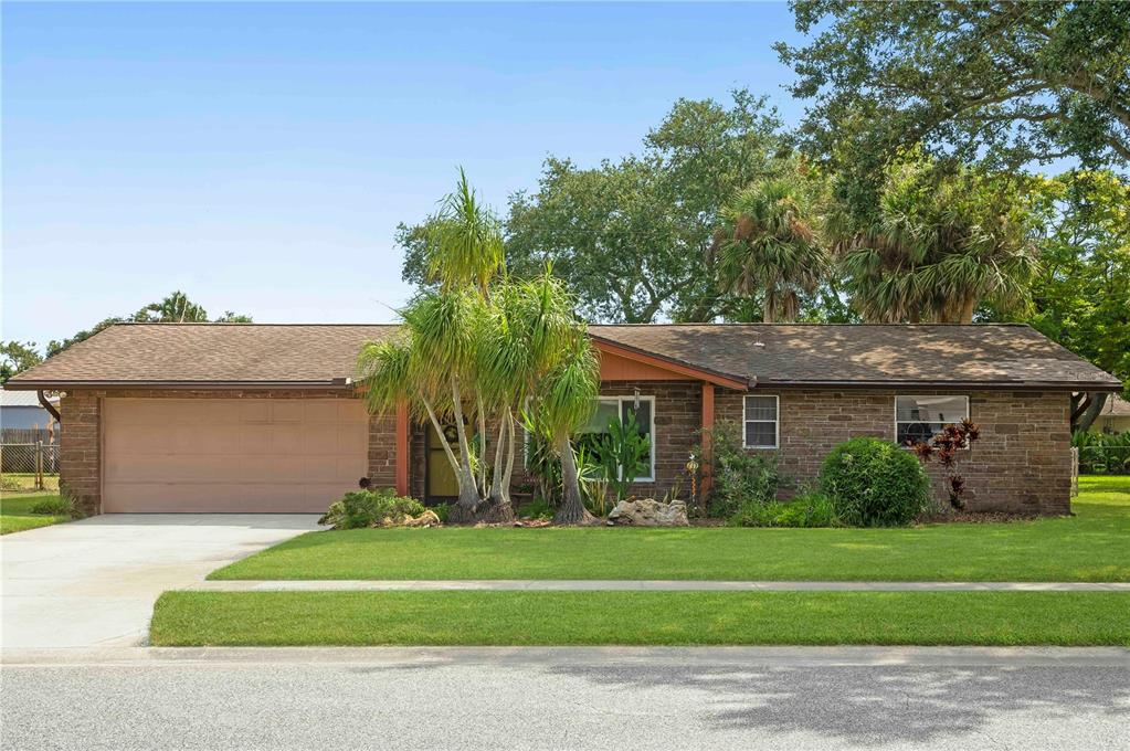 a front view of a house with a yard and a garage