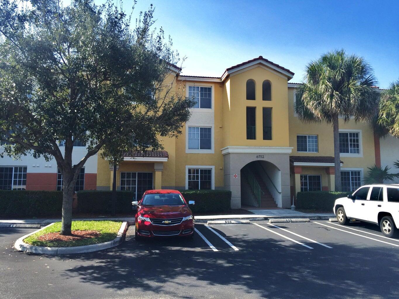 a front view of a house with a garden and parking