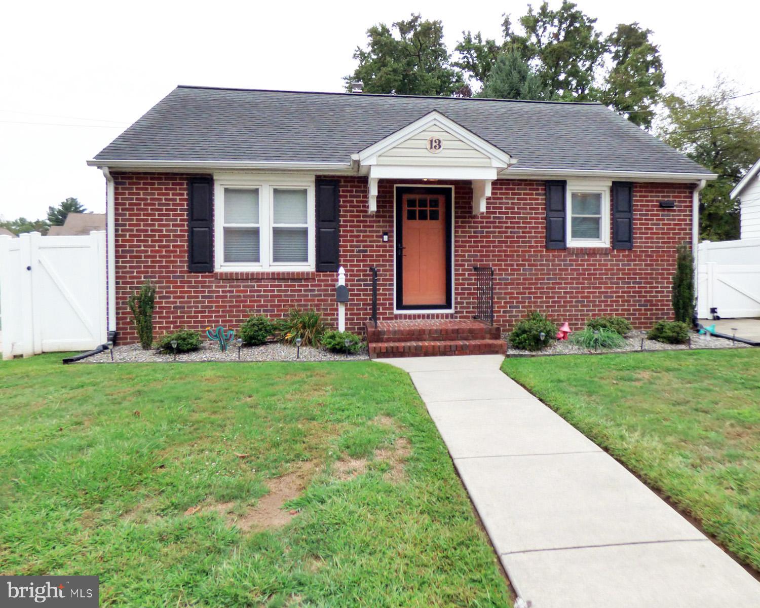 a front view of a house with a garden and yard