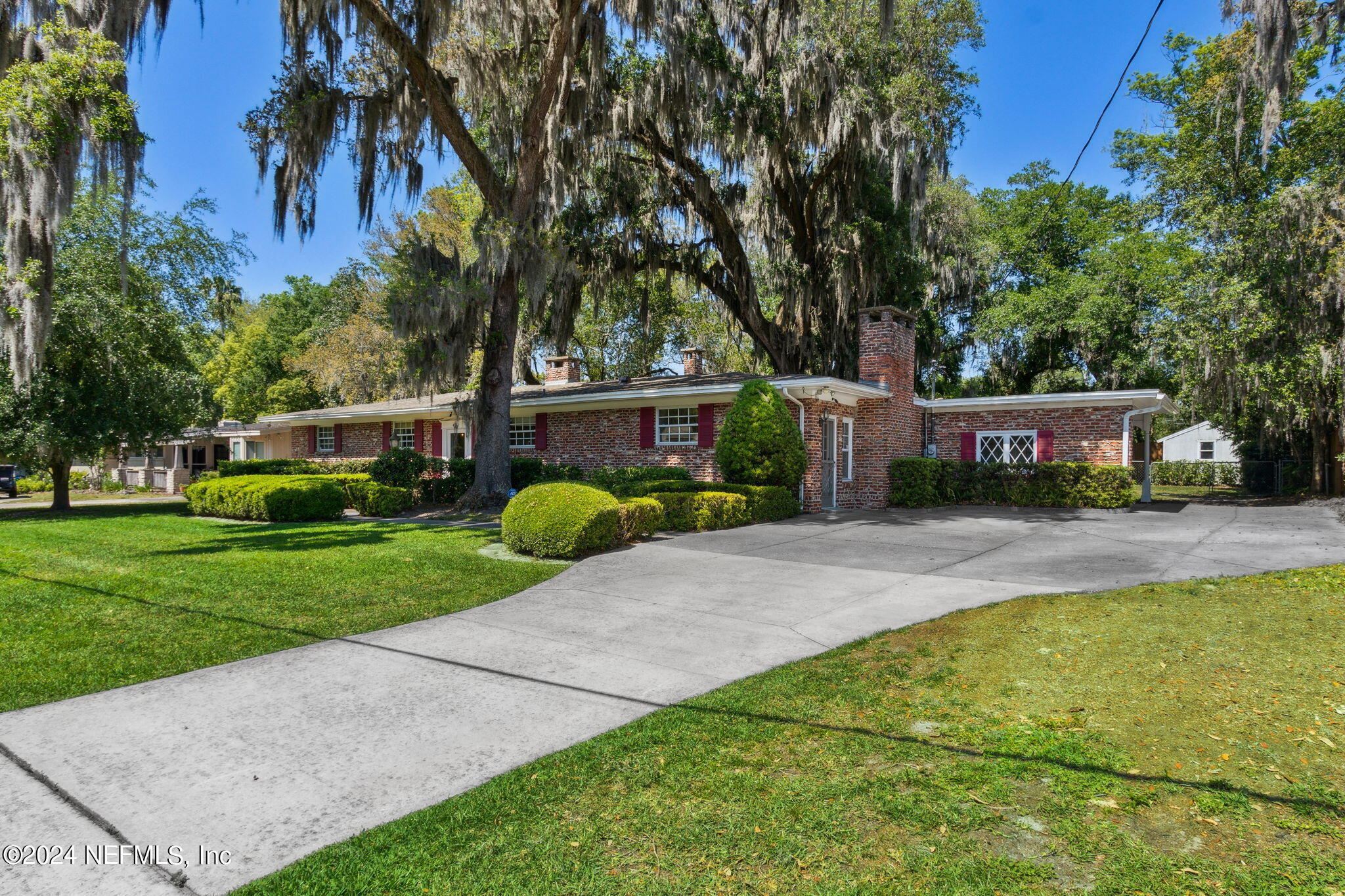 a view of a house with garden and trees