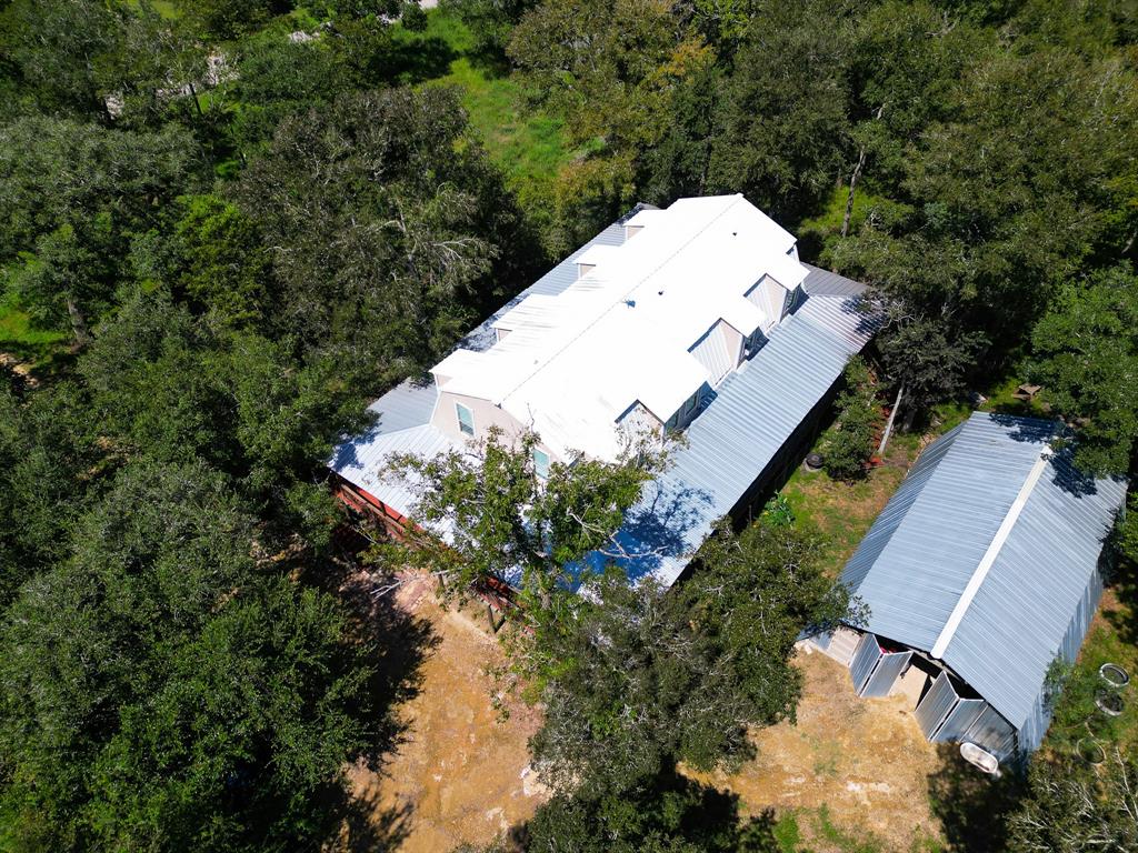 an aerial view of a house with a yard and large trees