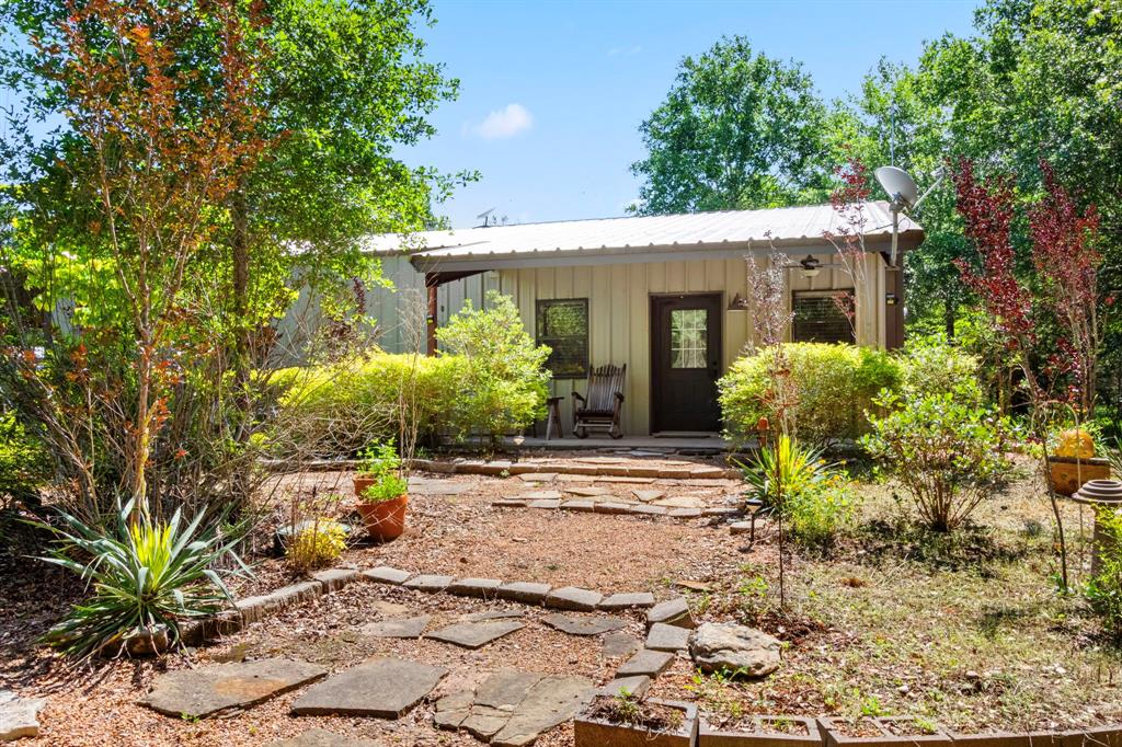 a front view of a house with a yard and potted plants