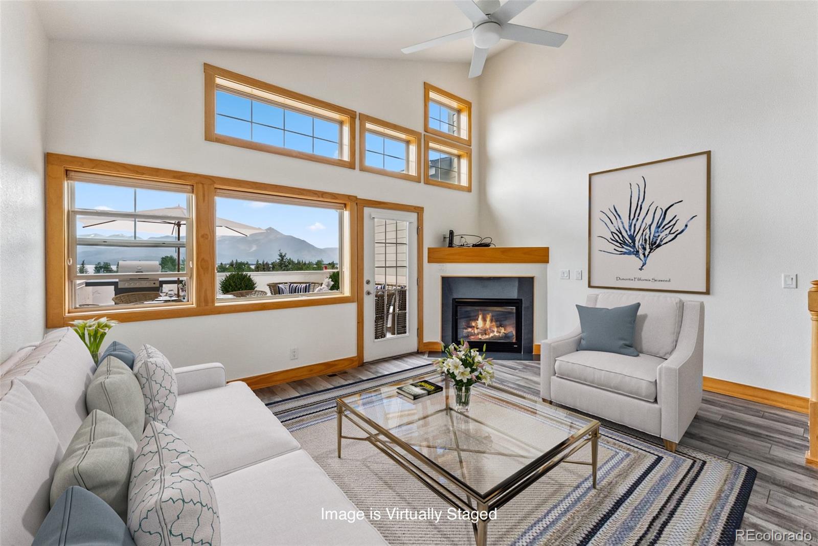 a living room with furniture a fireplace and a large window