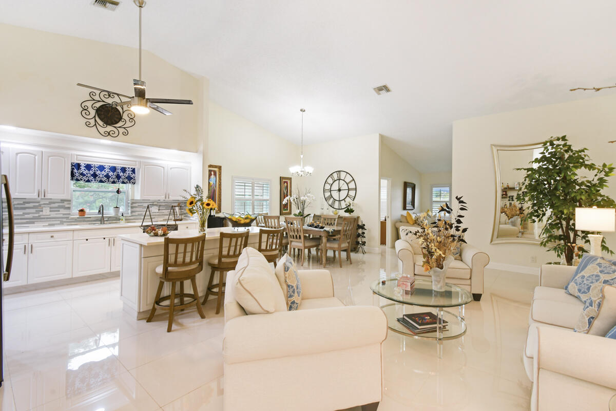 a living room with lots of white furniture and a chandelier