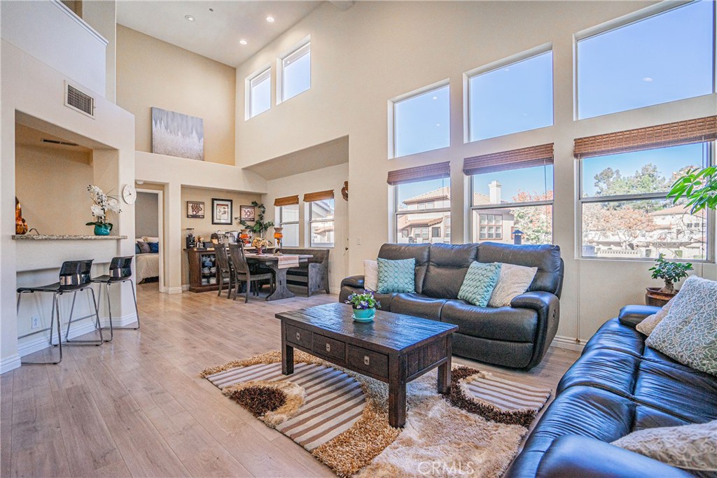 a living room with furniture wooden floor and a large window