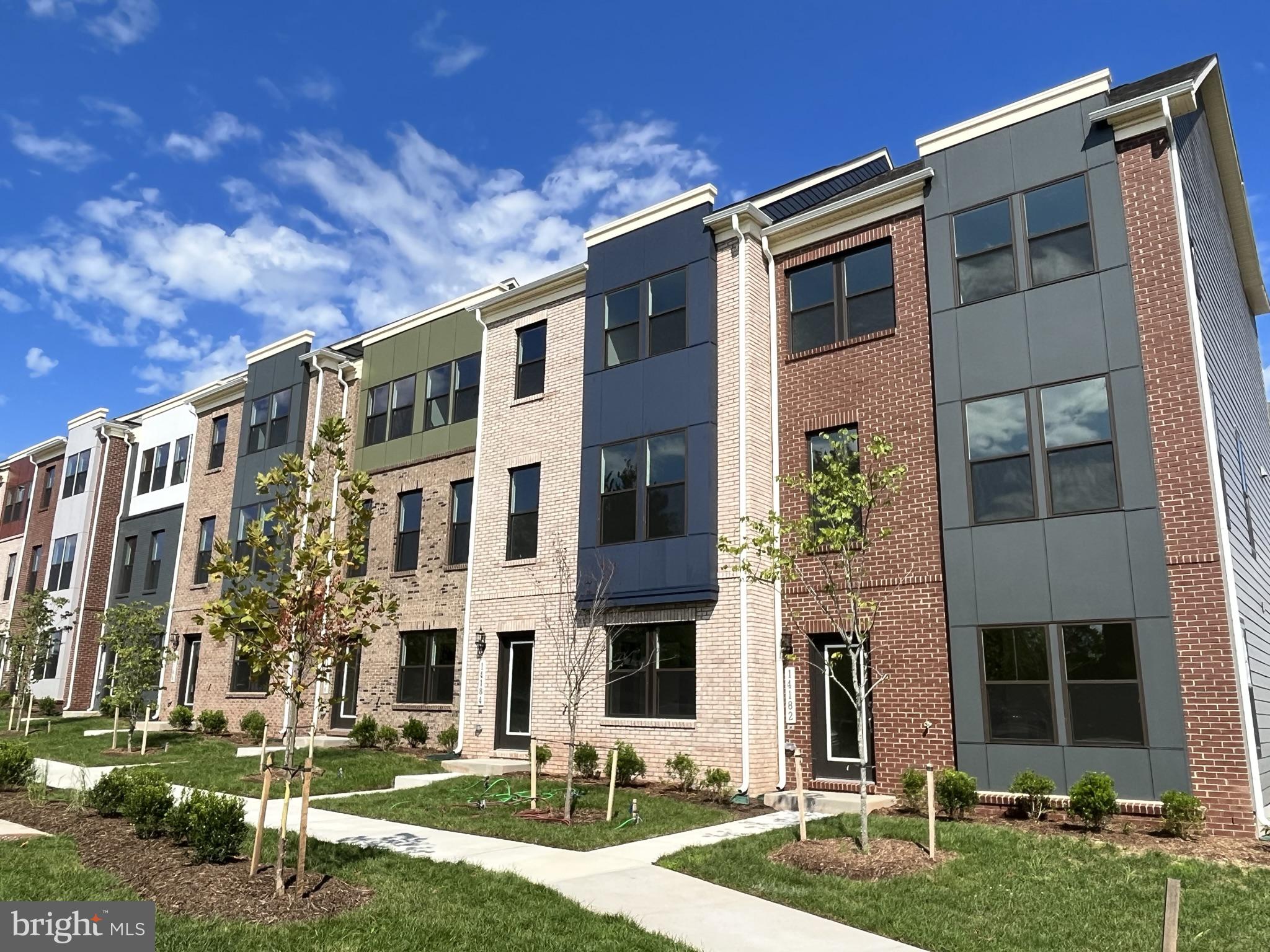 a front view of residential houses with yard and green space