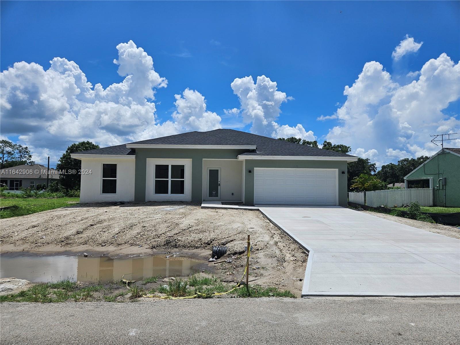 a front view of a house with a yard and a garage