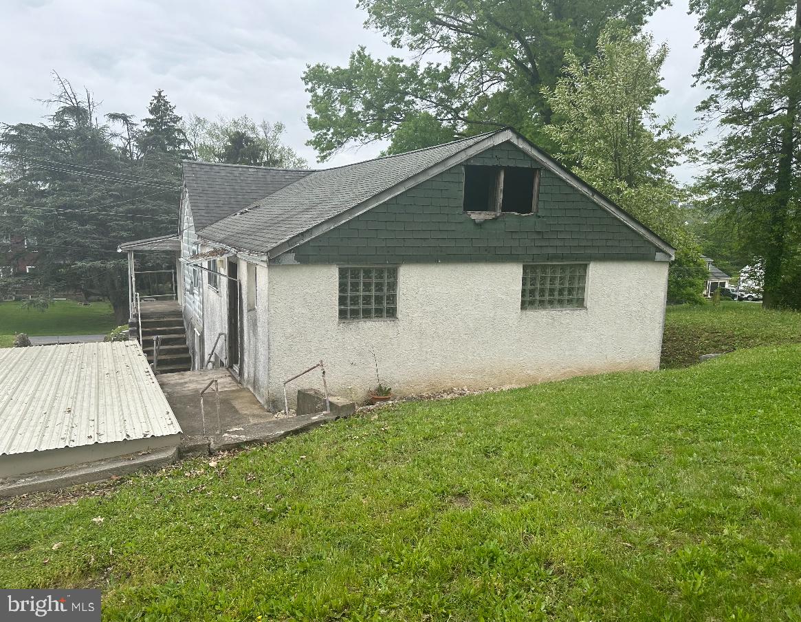 a front view of house with yard and trees in the background