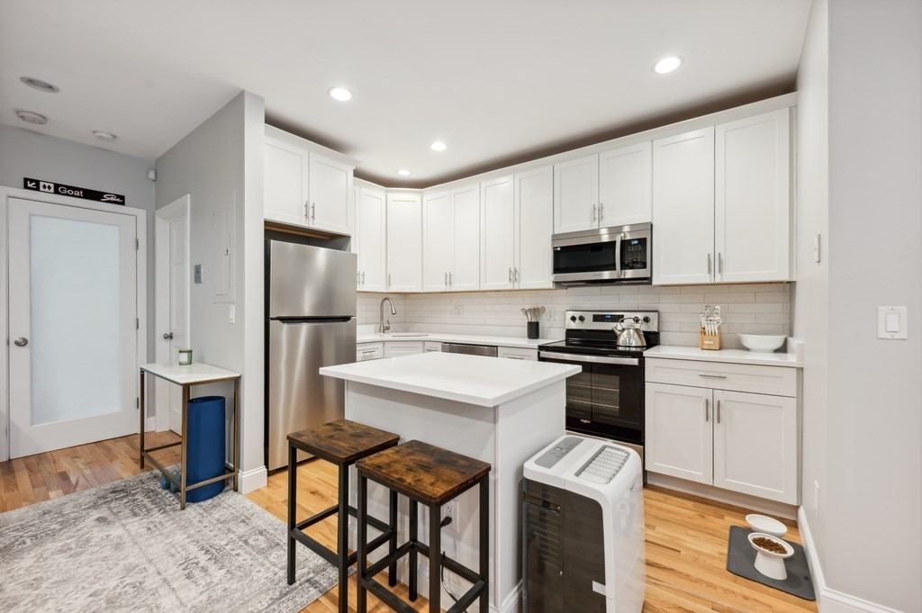 a kitchen with cabinets stainless steel appliances and sink