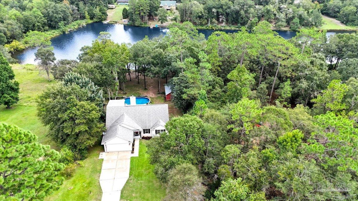 an aerial view of a house with a yard and lake view