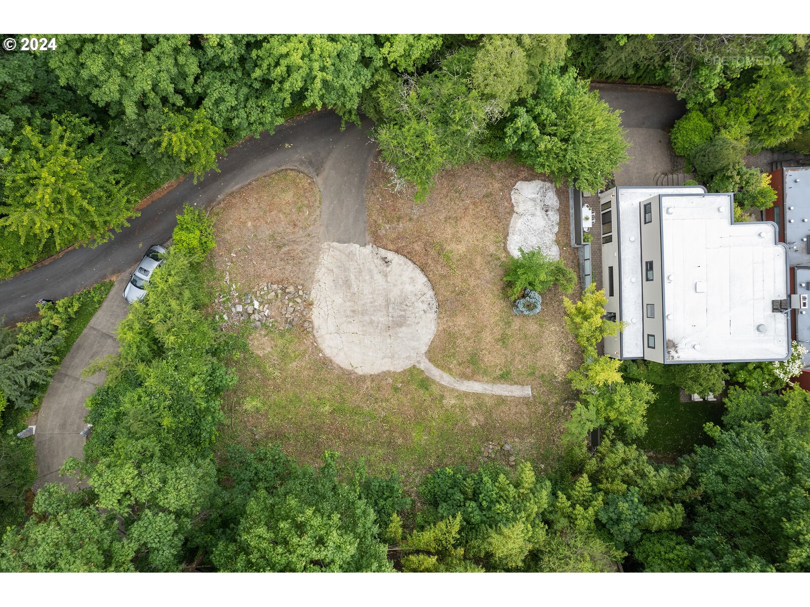 a aerial view of a house with a yard and large trees