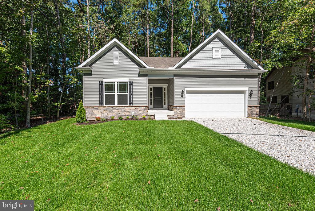 a front view of a house with a yard and green space