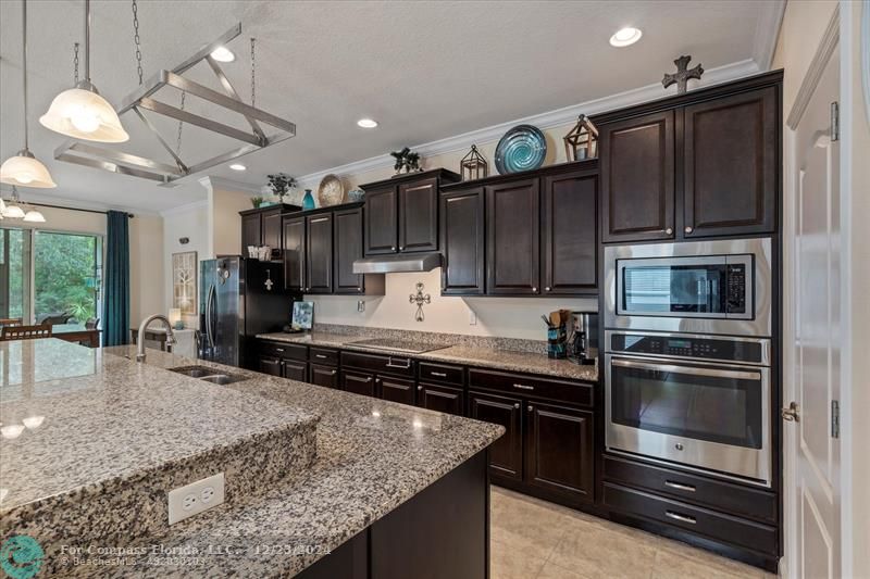 a kitchen with kitchen island a counter space a sink and stainless steel appliances