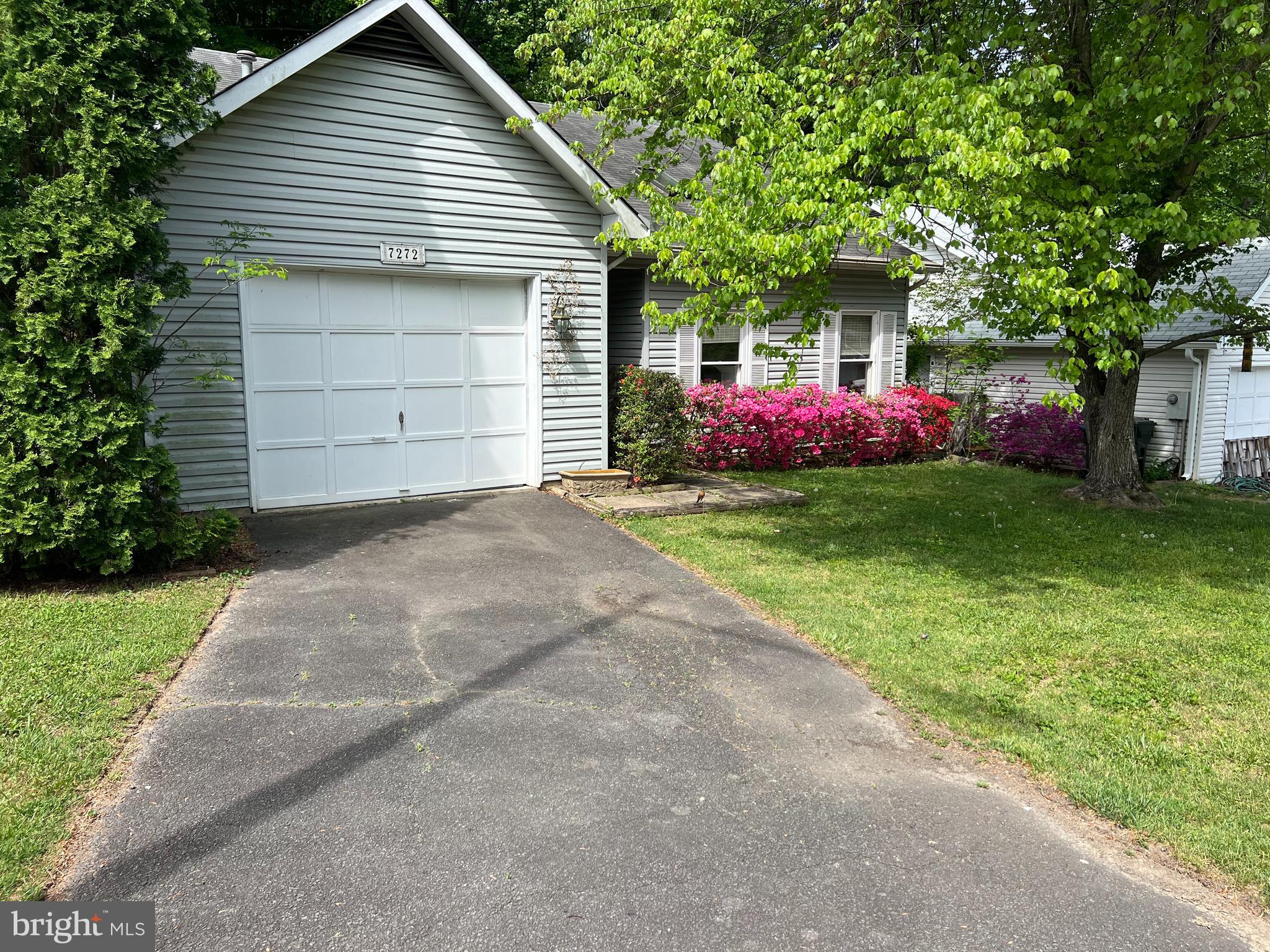 a front view of a house with a garden and yard