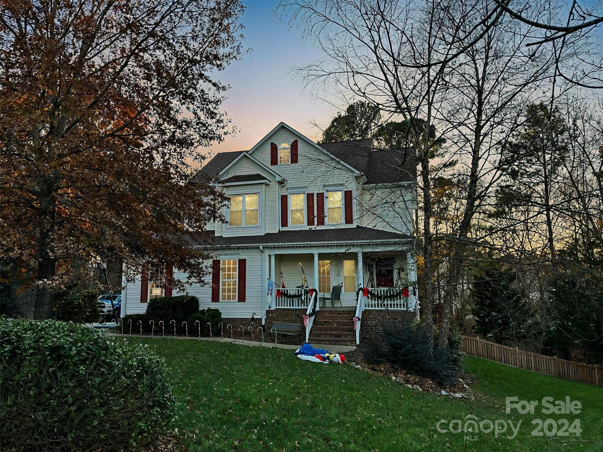 a front view of a house with a yard and green space