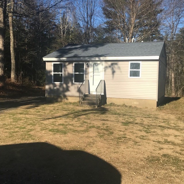 a view of a house with backyard and tree