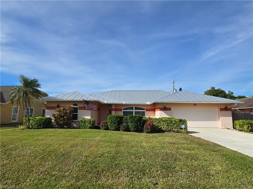 Ranch-style home featuring a garage and a front lawn