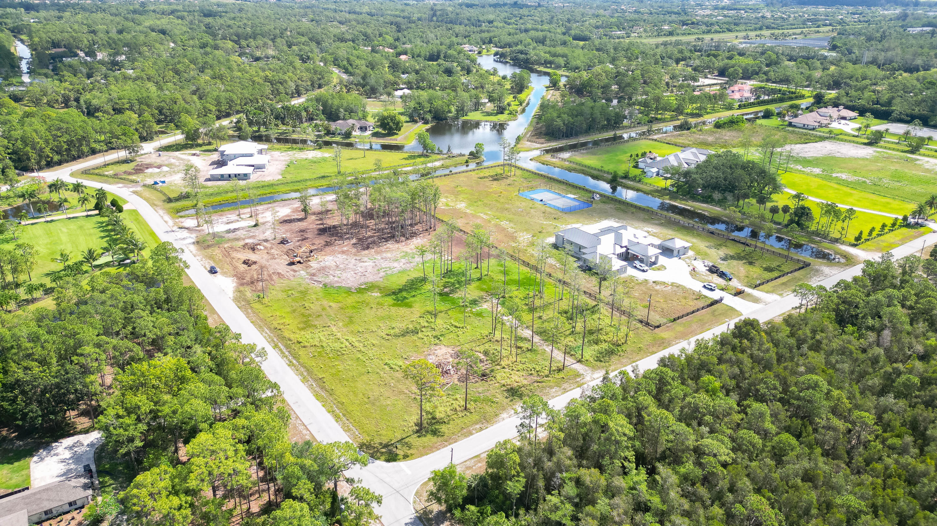 an aerial view of residential houses with outdoor space and trees