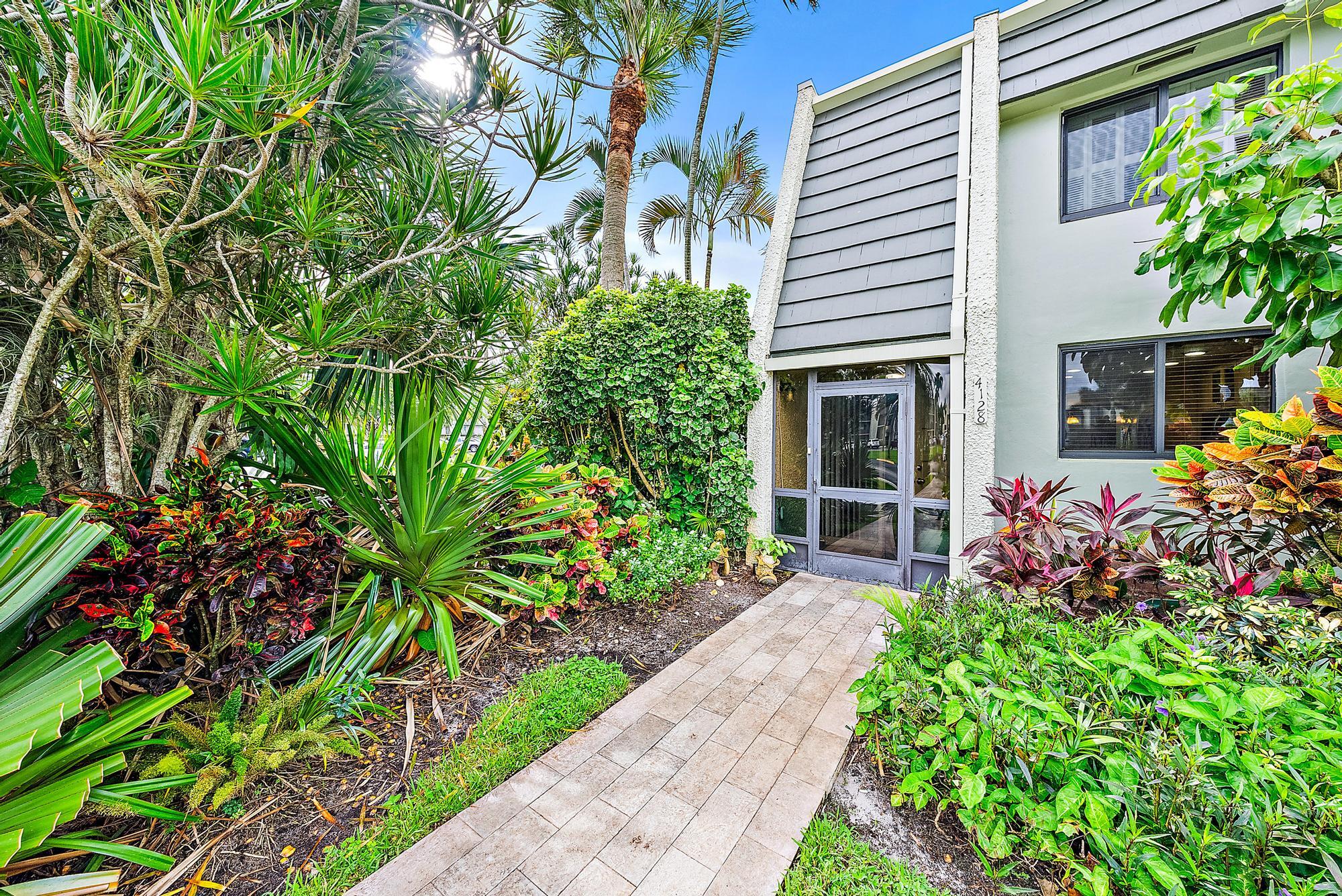 a front view of a house with a yard and potted plants