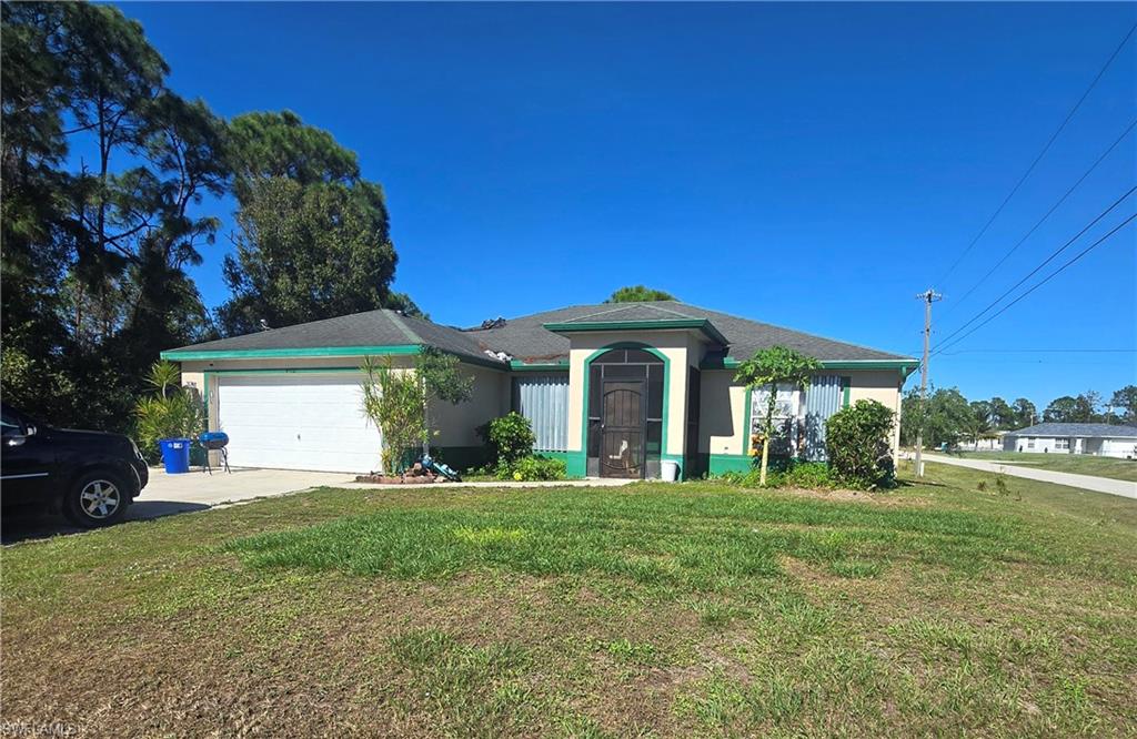 Single story home featuring a front lawn and a garage