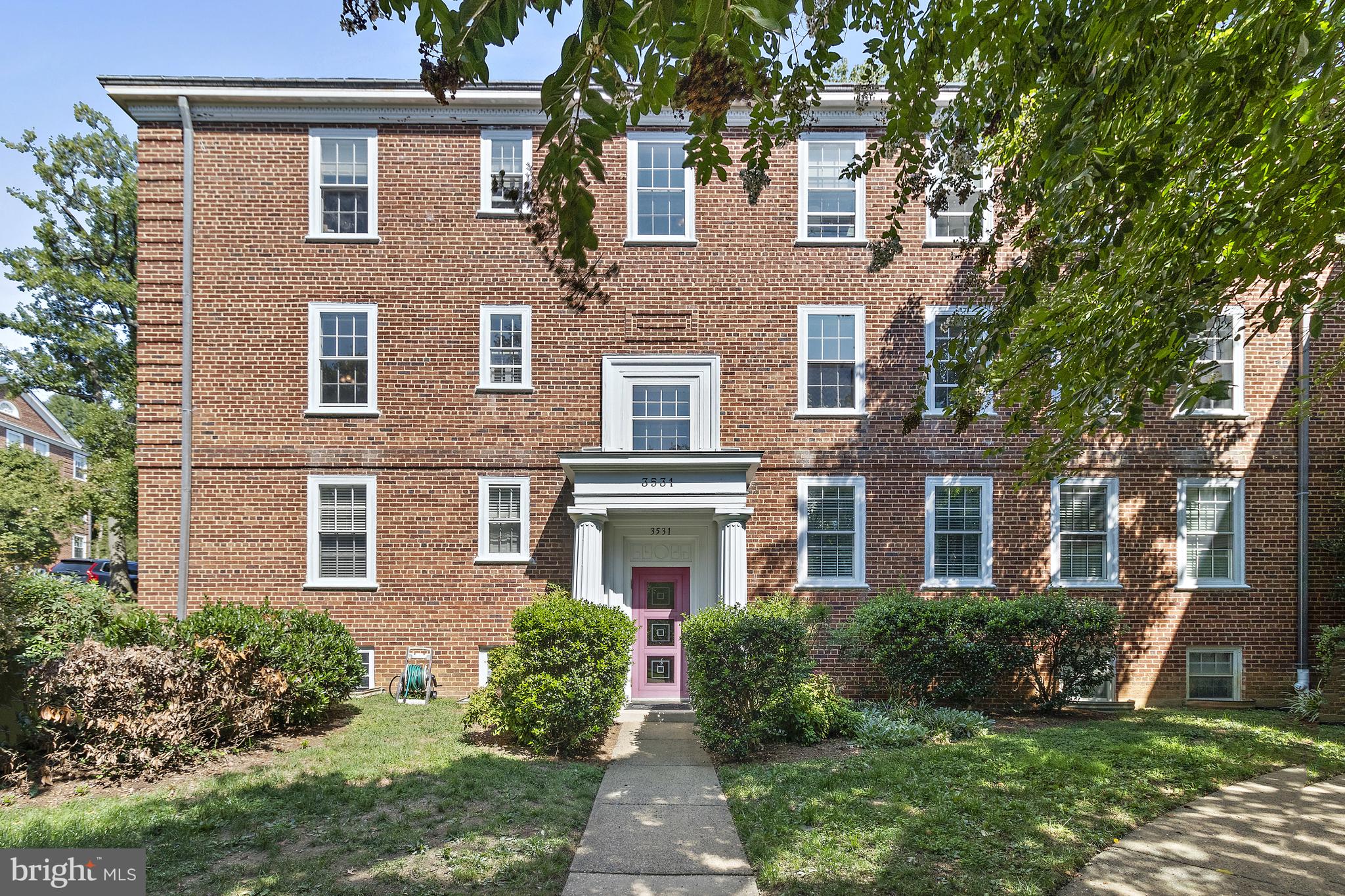 front view of a brick house with a yard