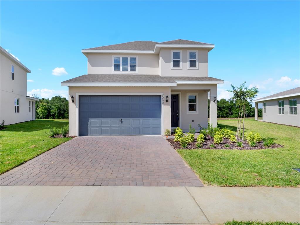 a front view of a house with a yard and garage