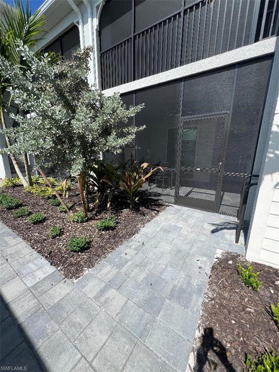 a backyard of a house with potted plants and large tree