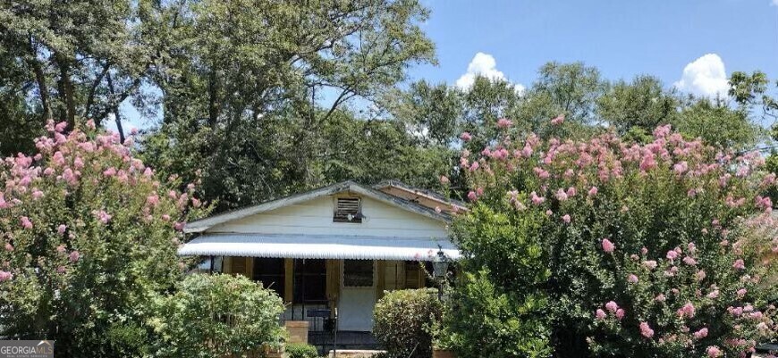 a front view of a house with a yard and trees