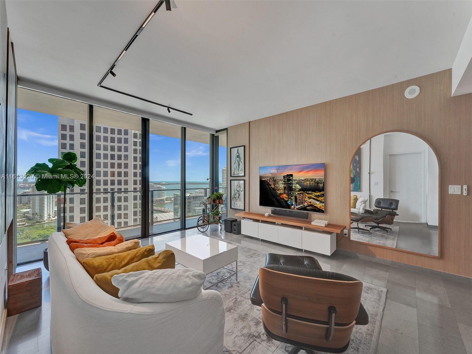 a living room with furniture a flat screen tv and potted plants