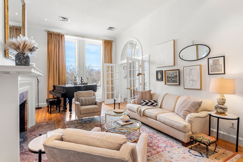 a living room with furniture fireplace and a large window