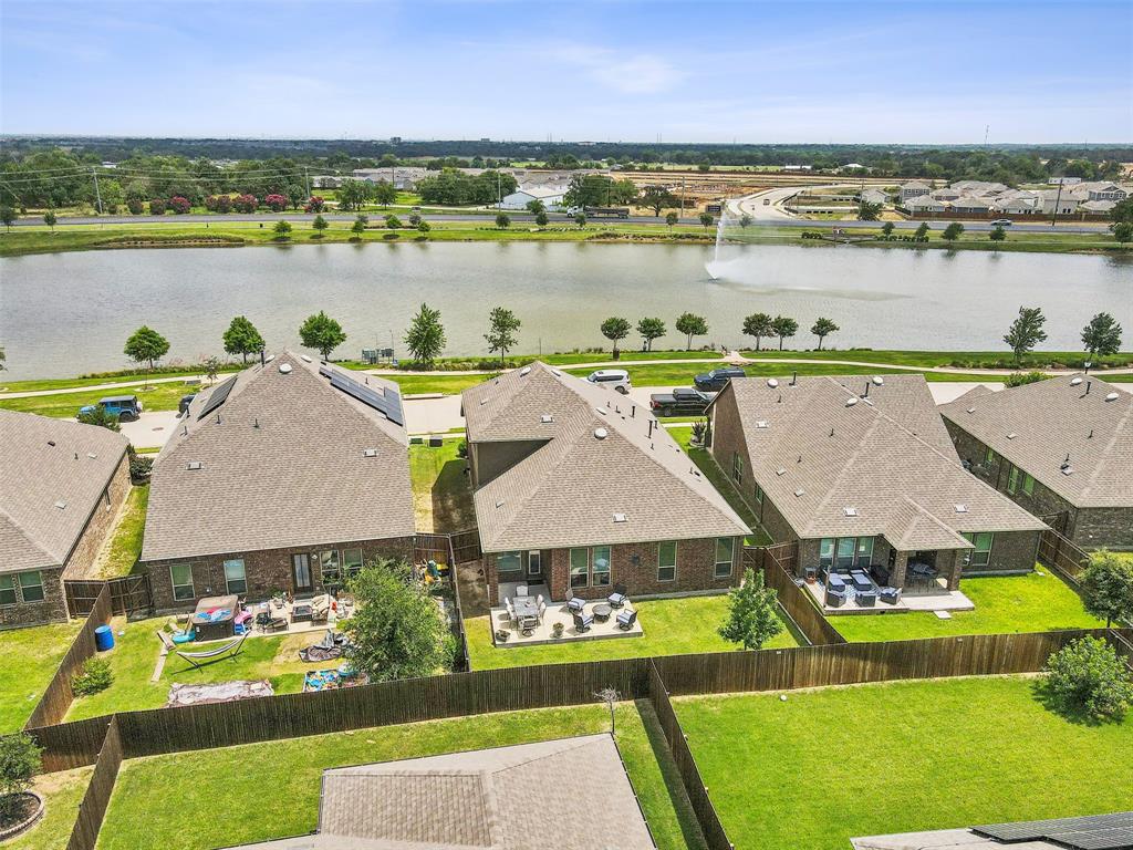 an aerial view of a residential houses with outdoor space and ocean view