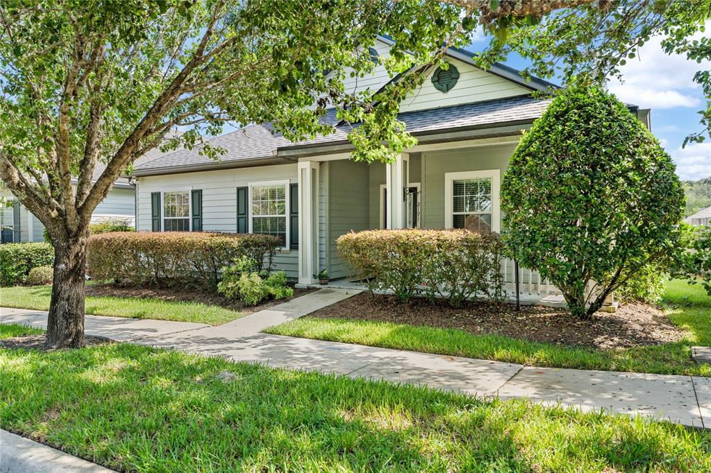 a view of a house with a yard and large tree