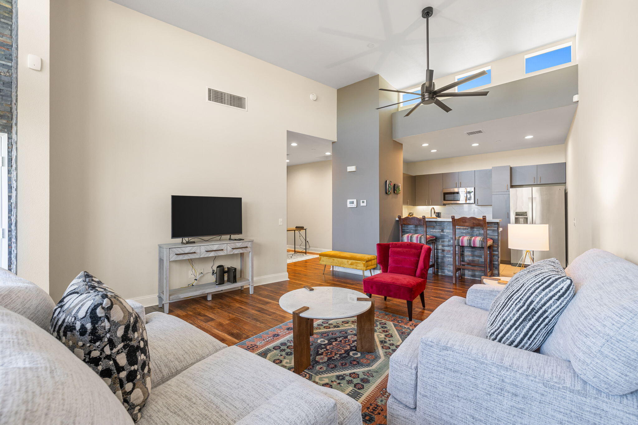 a living room with furniture kitchen view and a flat screen tv